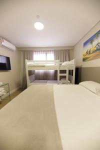 纳塔尔Easy Suites Natal的一间带两张双层床和电视的卧室