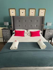 爱丁堡敖彬别墅酒店的一间卧室配有一张带红色枕头的大床
