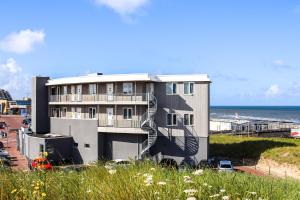 海边的艾格蒙特Lido Zeezicht appartementen的一座带螺旋楼梯的建筑,毗邻大海