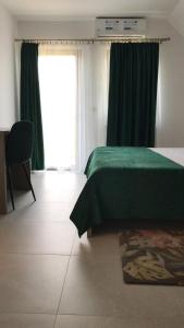 GalşaLa Foresteria的一间卧室设有一张绿色的床和一个窗户。