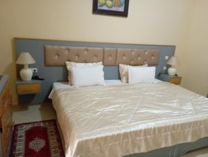 塔鲁丹特Almounia Hotel & Spa的卧室配有一张带白色床单和枕头的大床。