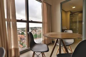 纳塔尔9006 Suites Natal Vista Mar的客房设有桌椅和大窗户。