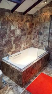 艾尔Havenwood的浴室设有带玻璃淋浴的浴缸