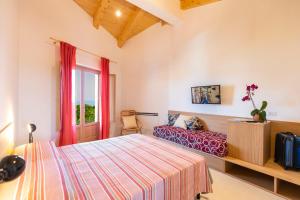 特罗佩阿HibiscusUno Tropea Residence的一间卧室设有一张床和一个窗口