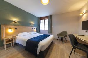 埃斯卡勒Hôtel L'Escale - Piscine & SPA的配有一张床和一张书桌的酒店客房