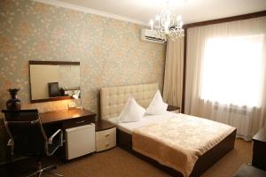 阿特劳美家园酒店的一间卧室配有一张床、一张书桌和一面镜子