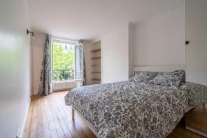 巴黎logement cosy et moderne proche de toute commodité的一间卧室设有一张床和一个窗口