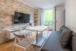 巴黎logement cosy et moderne proche de toute commodité的客厅配有桌椅和砖墙