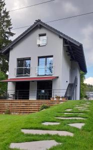 伏尔塔瓦河畔利普诺Apartmány Aktiv Lipno的一座带台阶的绿色山丘顶部的房子