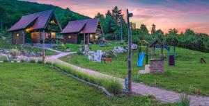 科雷尼察Holiday Park Plitvice Paradise的田野上的小木屋,带游乐场