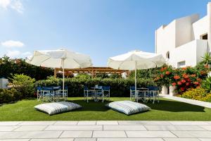 纳克索乔拉伊卡洛斯一室公寓酒店的一个带桌椅和遮阳伞的庭院