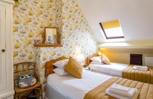 埃文河畔斯特拉特福Broadlands Guest House的酒店客房,设有两张床和镜子