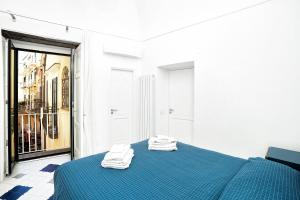 阿马尔菲La Finestra sul Corso的一间卧室配有蓝色的床和2条毛巾