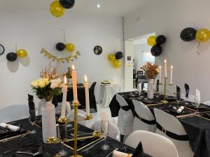 约翰内斯堡Semeni Asante Guesthouse的用餐室配有带黑黄色气球的桌子
