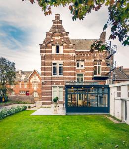 通厄伦Boutique Hotel Huys van Steyns的一座带绿色草坪的大型砖砌建筑