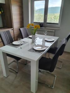 科佩尔Apartma Maja, Mateja的白色的餐桌,配有椅子和鲜花