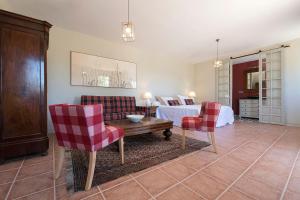 科尼尔-德拉弗龙特拉CORTIJO LA MINA - Luxury Villa Conil的一间卧室配有一张床、两把椅子和一张桌子