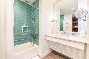 奥兰多Margaritaville Resort Orlando的带浴缸、水槽和镜子的浴室