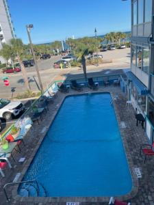 默特尔比奇Ocean 5 Hotel的一座大型蓝色游泳池,位于大楼旁边