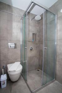 切什梅Cesurlar Hotel的浴室设有玻璃淋浴间和卫生间
