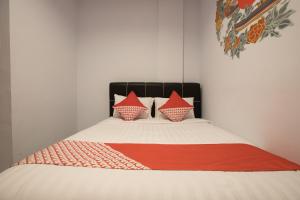 雅加达OYO 176 Near Cideng Virgo Residence的一张带两个枕头和红色毯子的床