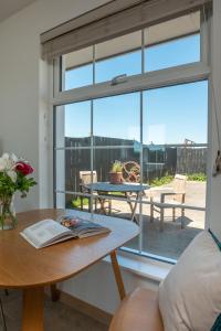 金斯布里奇Furlong Cottage @ Higher Stancombe Farm的客厅配有桌子和玻璃窗