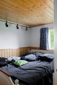 SuonenjokiMummon mökki - Granny´s cottage的木天花板的客房内的一张床位