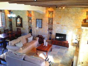 洛弗Lofou Traditional Stone House的带沙发和石墙的客厅