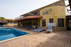 亚喀巴达纳潜水员村庄旅馆的大楼前设有游泳池的酒店