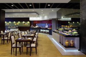 迪拜Millennium Central Downtown的一间带桌椅的餐厅和一间酒吧