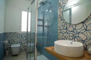 马里迪莫Casa della barchetta rossa的一间带水槽、淋浴和镜子的浴室