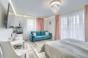 斯维诺乌伊希切Silver Apartments的一间卧室配有蓝色的床和沙发