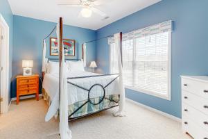 柏斯海滩Eagles Landing - 4300 Sandpiper #4314的蓝色卧室,配有一张带天蓬的床