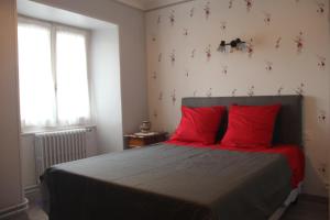 MieussyChez Gilles et Christine的一间卧室配有一张带红色枕头的床和一扇窗户