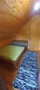 科拉欣Crkvine Chalet的一张位于带地毯的木制房间内的床铺