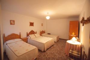 卡索拉Casa Rural José María的酒店客房,设有三张床和两张桌子