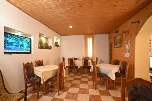 AndrijevicaKomovi Eko katun的一间带桌椅和电视的用餐室