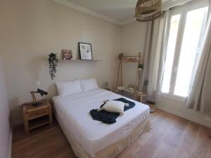 尼斯Appartement, 3 pièces, Villa Monte Europa的一间卧室配有一张带白色床单和窗户的床。