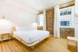 魁北克市La Maison des Lofts - Par les Lofts Vieux-Quebec的一间卧室设有一张床和砖墙