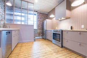 魁北克市La Maison des Lofts - Par les Lofts Vieux-Quebec的铺有木地板和砖墙的厨房