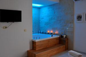 奥特朗托BluOtranto的一间带浴缸的浴室,墙上配有电视