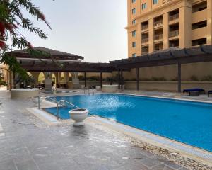 多哈Alken Studio - Amazing Superior Studio with Marvellous Marina View in the Pearl, Doha的一座带卫生间的游泳池位于大楼旁