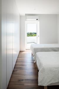 阿尔曼萨Casa Monte dos Entrudos的一间卧室设有两张床和窗户。