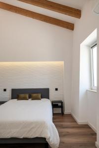 阿尔曼萨Casa Monte dos Entrudos的卧室配有白色墙壁和木地板。