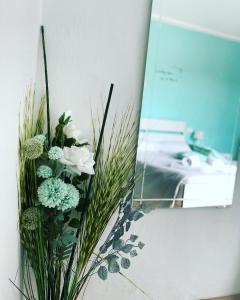 马斯诺维斯康蒂Il nido di Tiffany的墙上满是白色和绿色花的花瓶