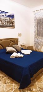 巴勒莫B&B VENTO DEL SUD的一间卧室配有蓝色的床和毛巾