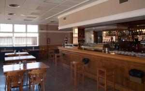 阿苏克卡德埃纳雷斯阿祖奎卡酒店的餐厅设有酒吧,配有木桌和椅子