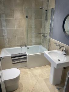 克利特Flosh Cottage Lake District的一间带水槽、浴缸和卫生间的浴室