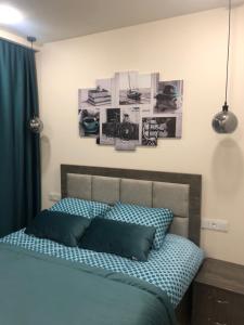 埃里温Karen's Dom & Terrace的一间卧室配有一张带蓝色枕头的床,墙上挂有图片