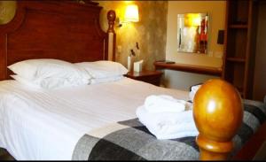 CairnessBan-Car Hotel的酒店客房,配有带毛巾的床